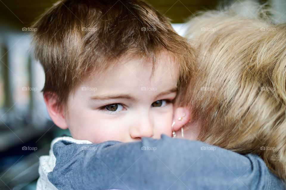 Close-up of a toddler boy hugging his grandmother