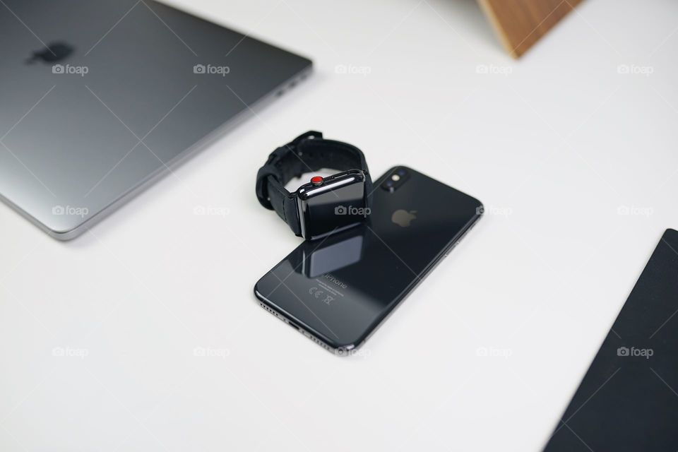 Apple phone with hand watch and laptop.