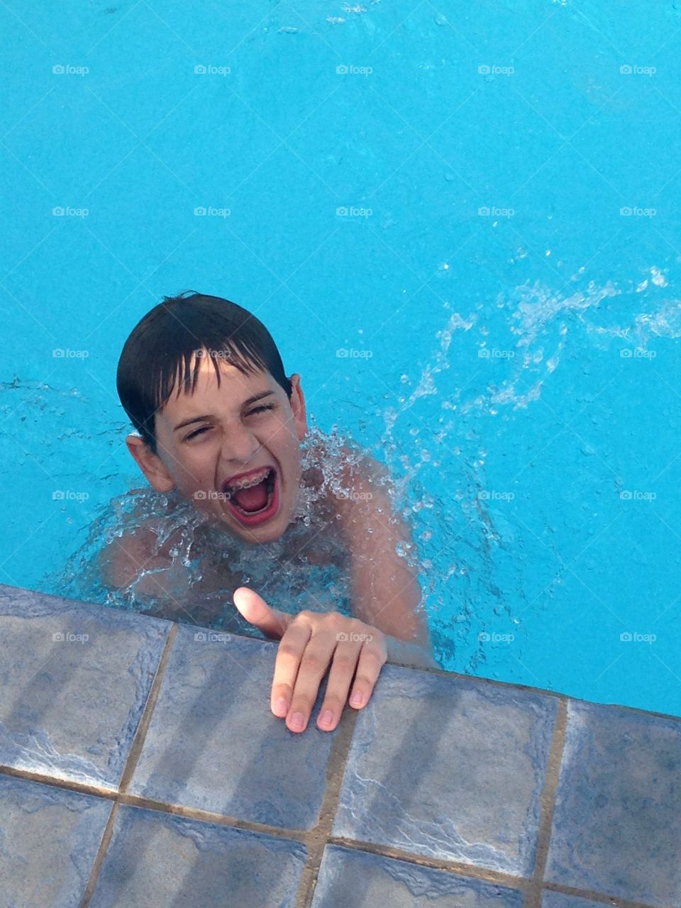 Waves of fun. Boy having fun at the wave pool at the water park 