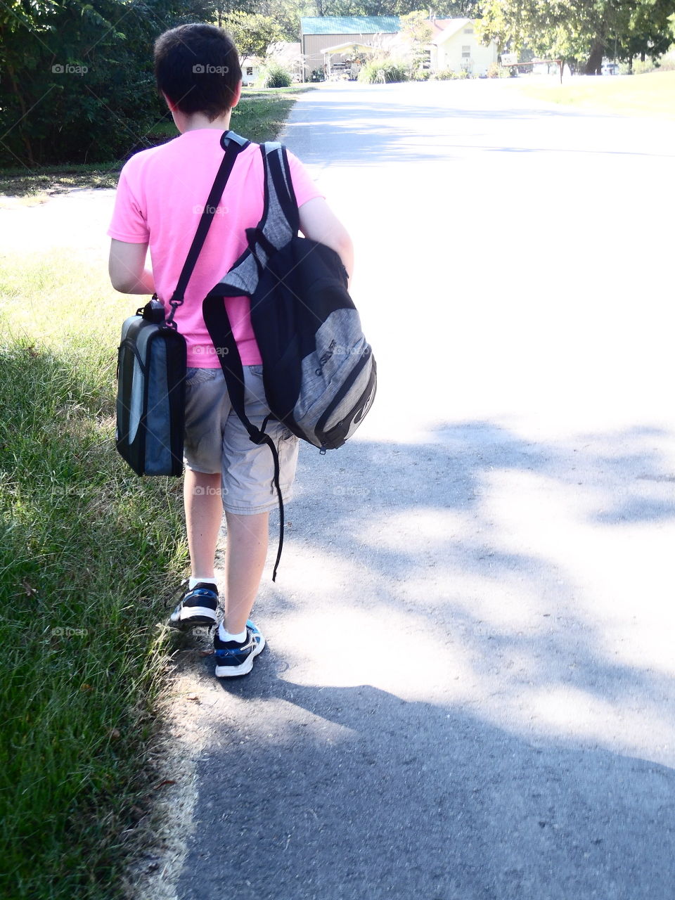 This is my brother. Every day at 3:50 pm, we walk home. It's a short walk since the bus stop is right next to our house. There is a lot of materials that we have to carry to and from school. Education is so important and we must have all of the materials we need to learn and grow. This makes a heavy haul worth it every day.