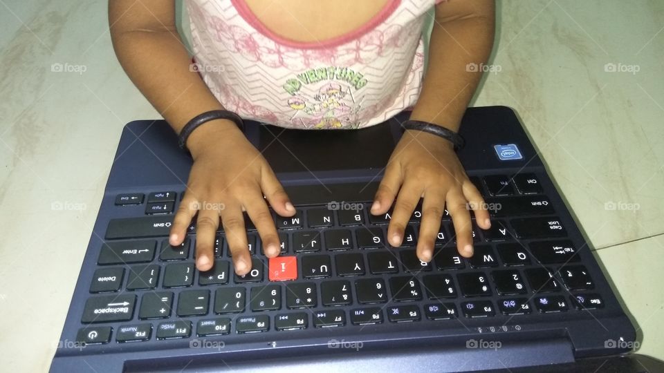 child operating laptop playing games