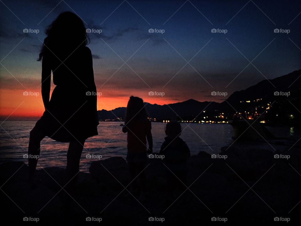 Silhouettes of mother and children during colorful sunset Dubrovnik Croatia 