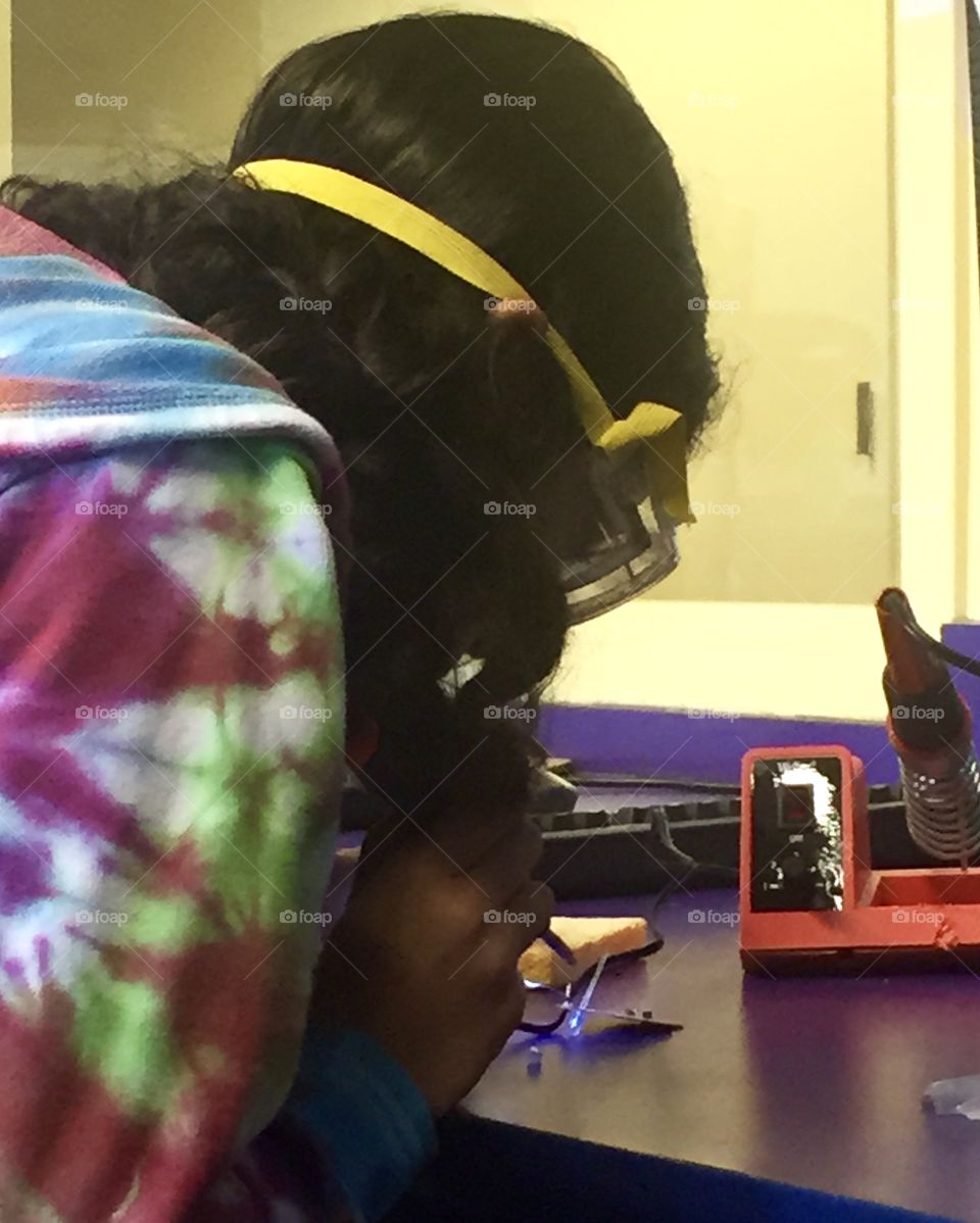 Girl soldering a science project 