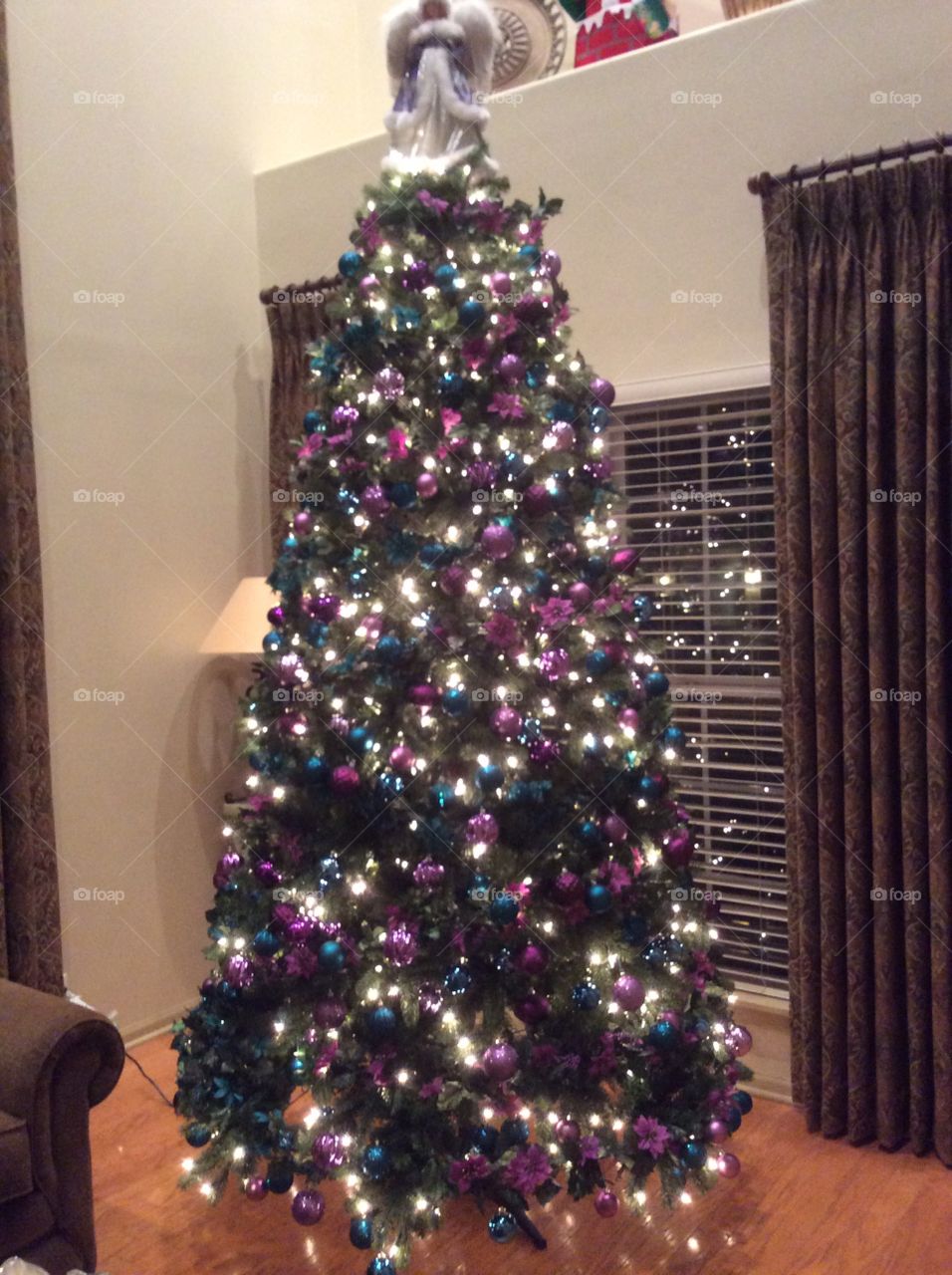 9 Foot Christmas Tree decorated with Teal and Purple Ornaments and Garland
