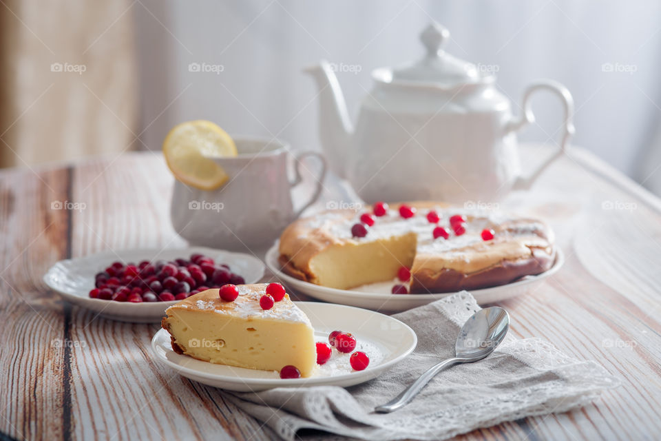 Cheesecake with cranberries and sugar on wooden background