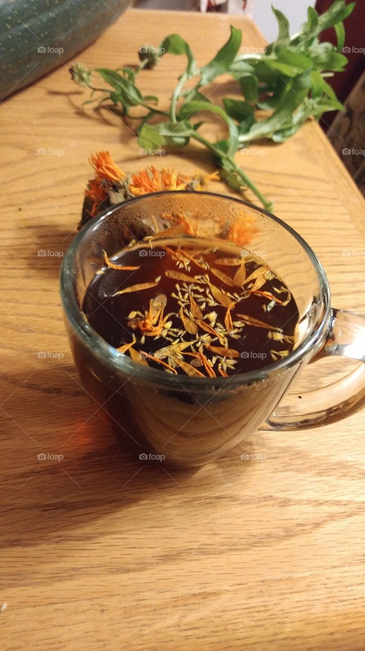 Herbal Tea on a Table with Marigolds and Spiky Lettuce