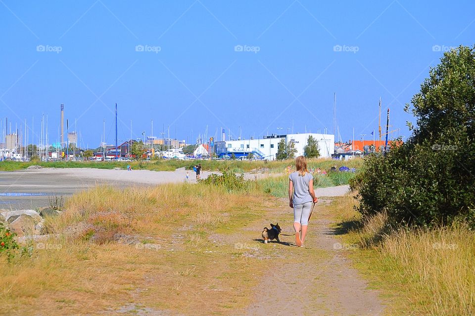 Girl walking. A girl wals with her puppy at the beach