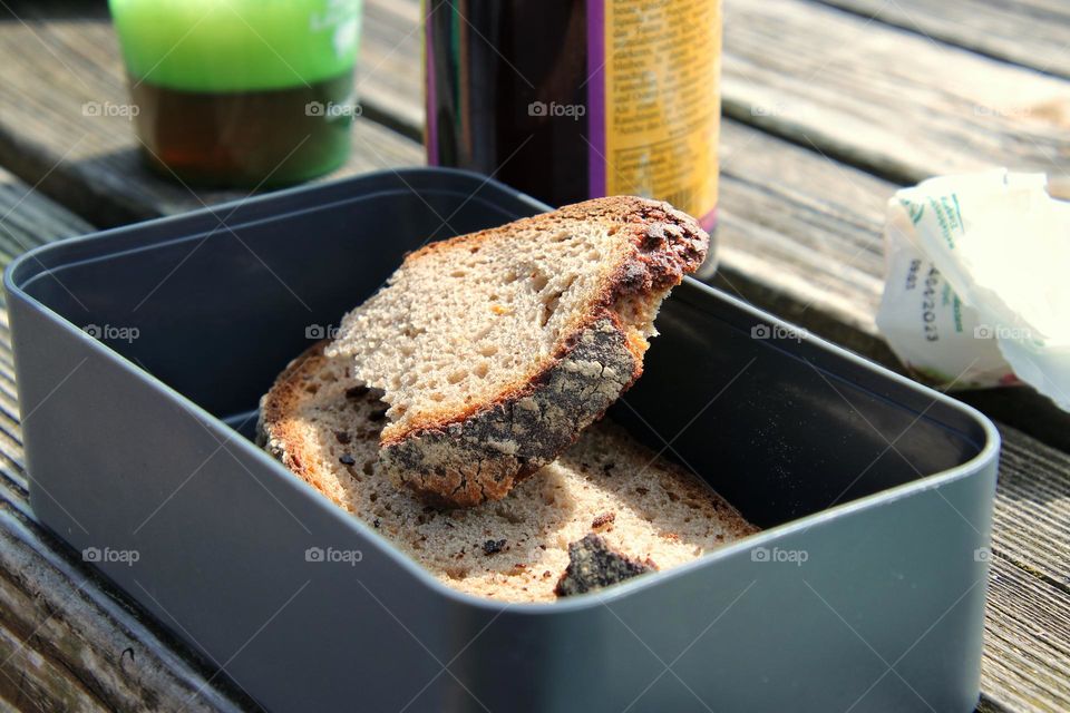 Close up of fresh bread in lunch box on wooden table