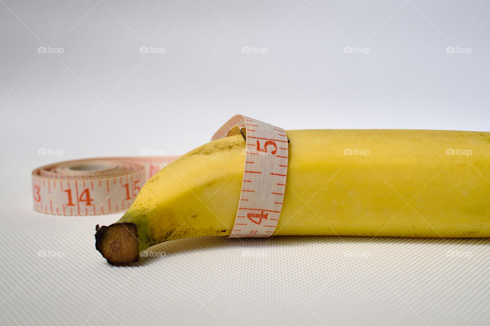 Penis size concept using banana, soft measuring tape