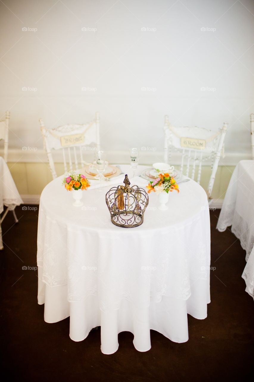 Small round wedding couple head table indoors 