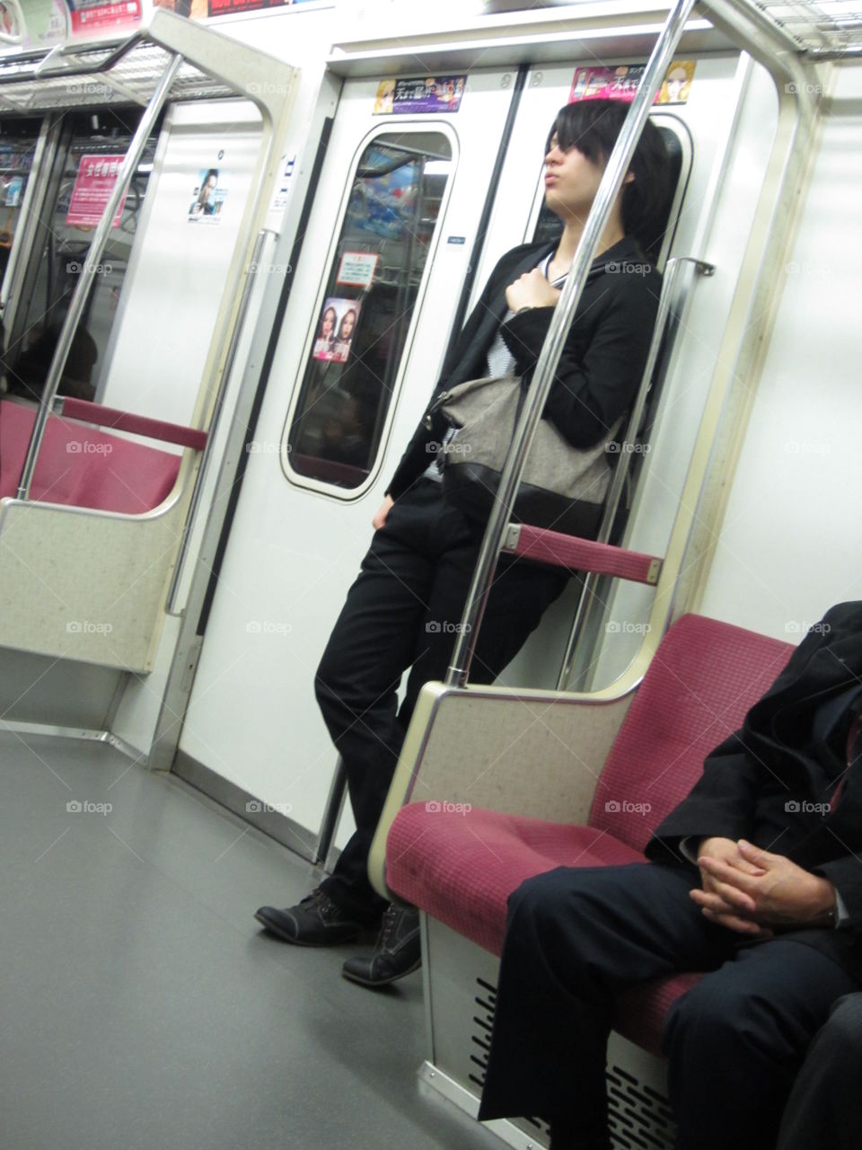 Young Man Standing in Train, Tokyo, Japan.