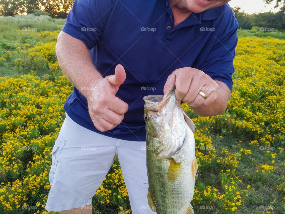 Man with thumbs up and smiling after catch a fish