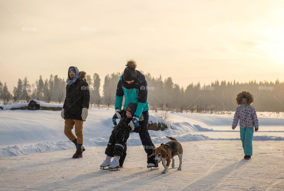 Happy family having fun on frozen lake