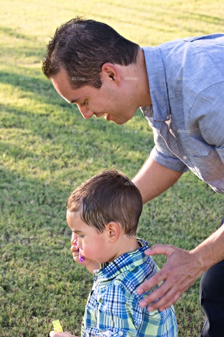 Father teaching son how to blow bubbles