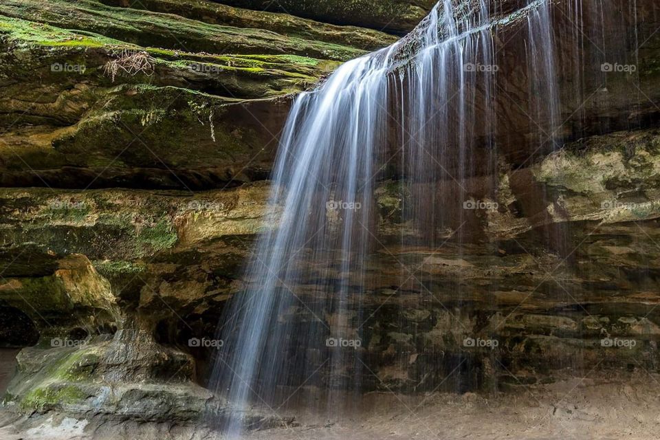 Long exposure of a waterfall shot over brown and grey rocks at Starved Rock national park in Illinois 
