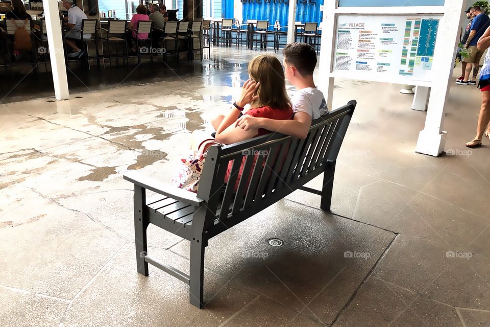 Couple relaxing on an outdoor bench.