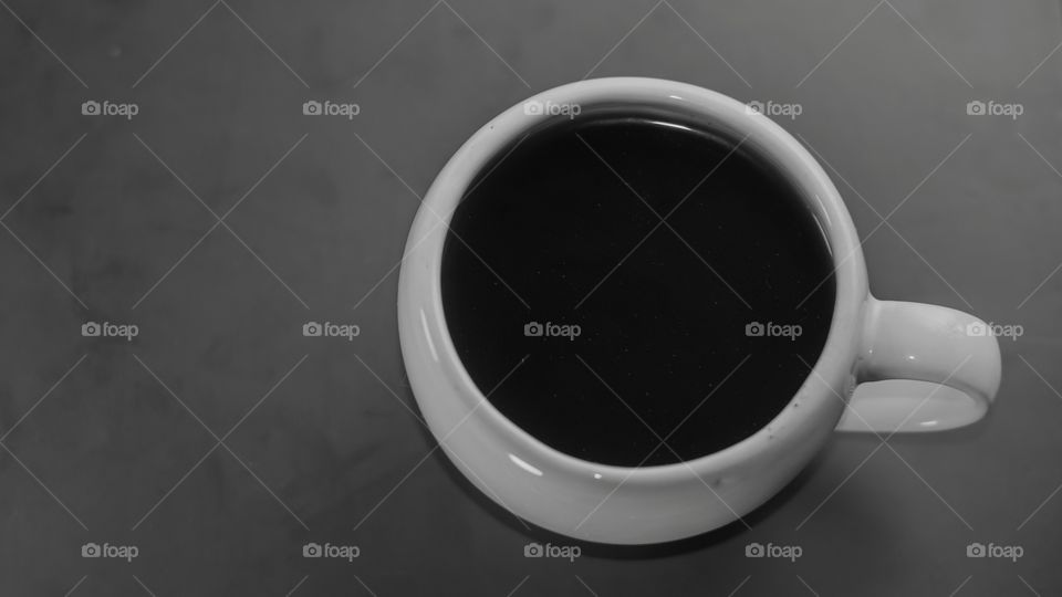 Coffee drink in a white cup on a gray table