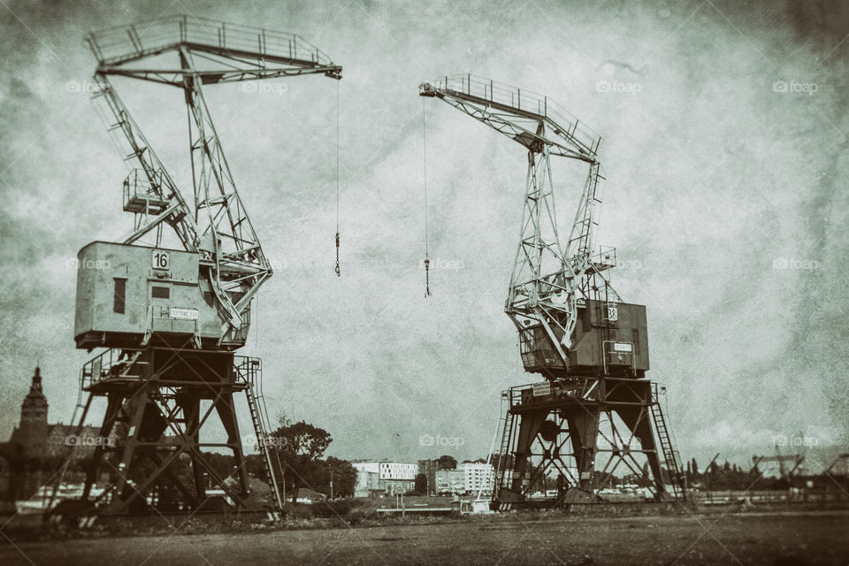 Retro cranes in old part of port. Photo stylized on retro photo.