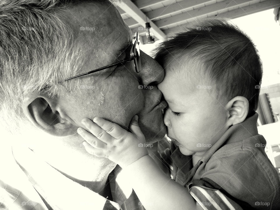 Grandfather kissing grandson on his forehead