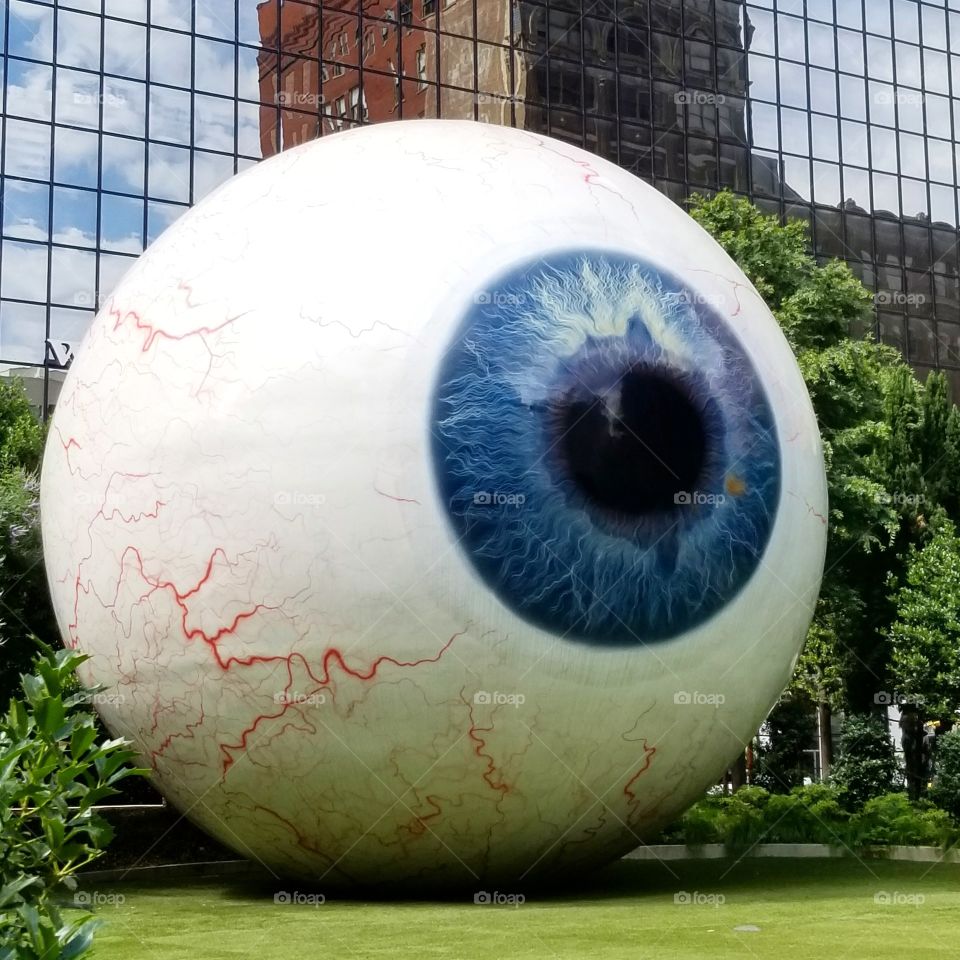 The Eyeball sculpture art in open space between buildings in Downtown Dallas