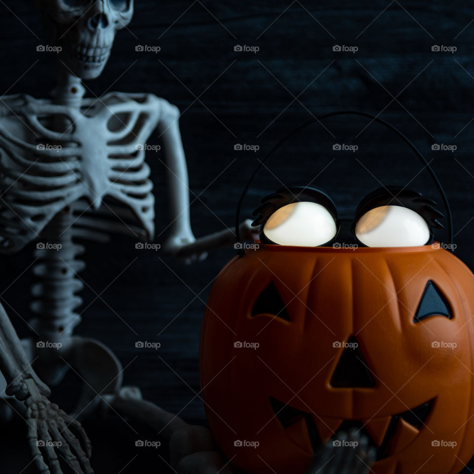 1:1 image of glowing eyes Halloween decorations next to a skeleton 