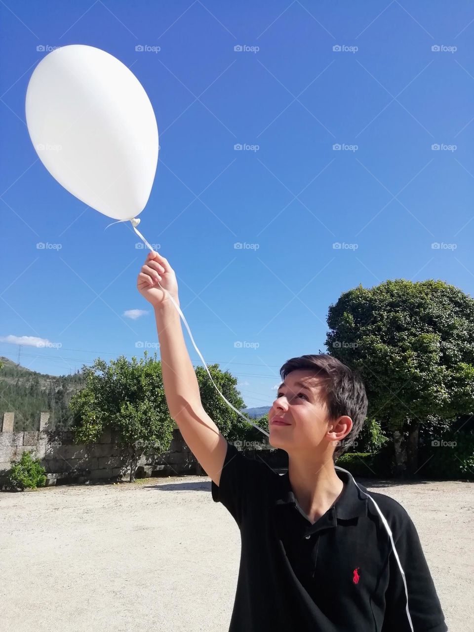 Young boy holding helium balloon