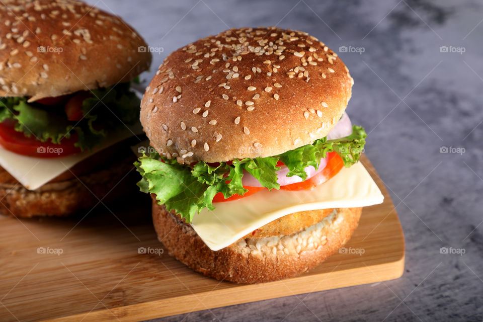 Fast food - burgers on a wooden mat with textured background