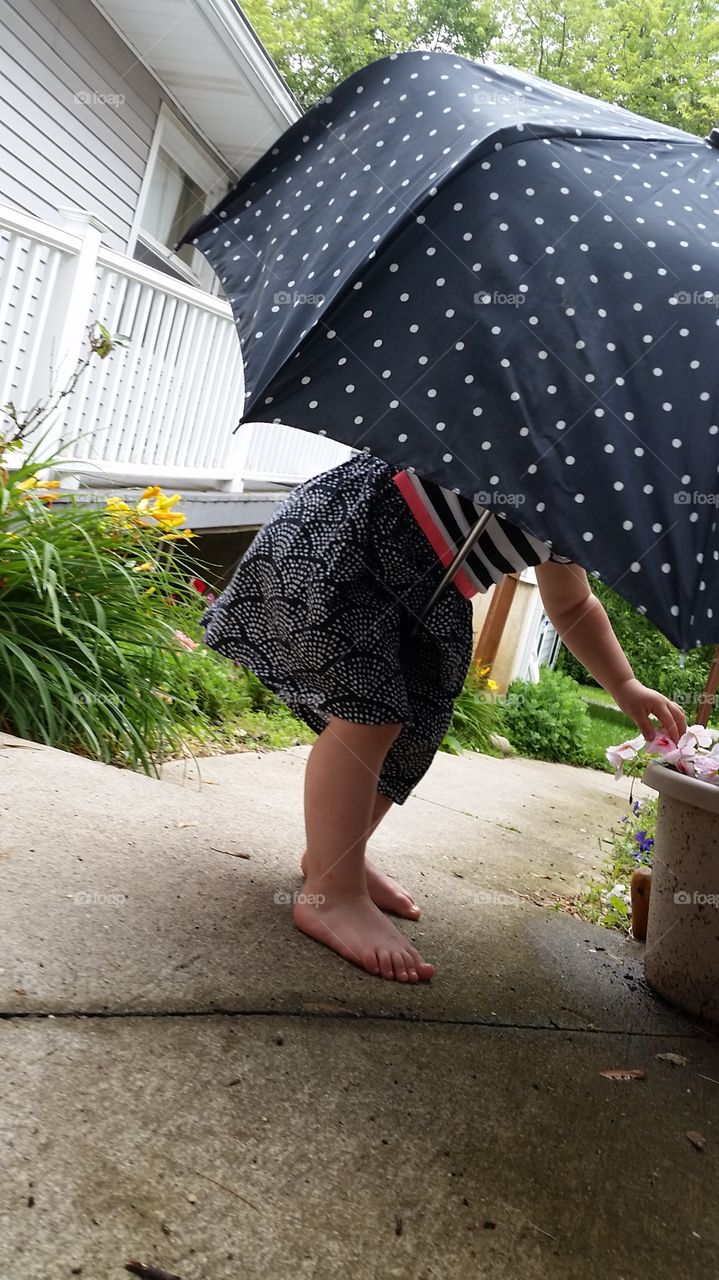checking raindrops on flowers. sis loves her garden
