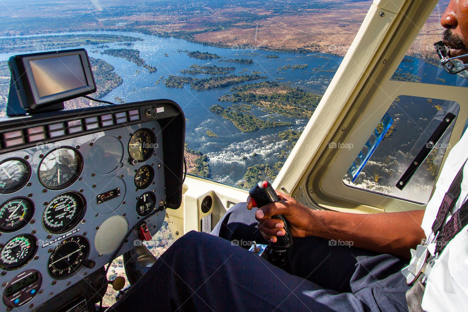 One of the most amazing hobbies -flying!  Image of helicopter pilot, inside of helicopter and scenic view over a river in Africa