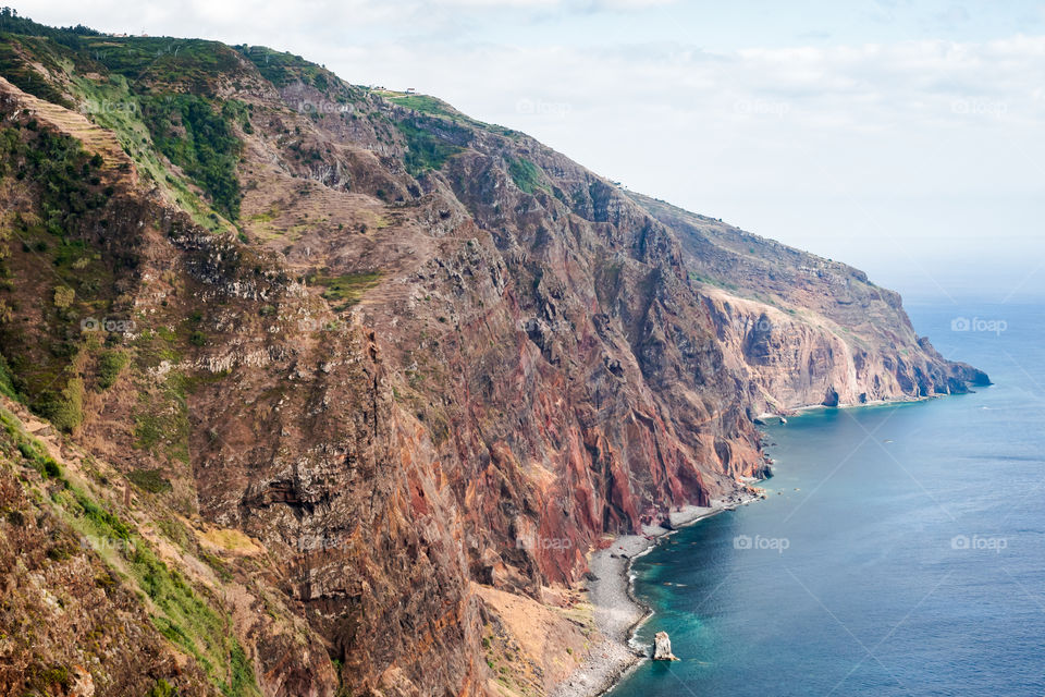 Rocky red cliff in the ocean 