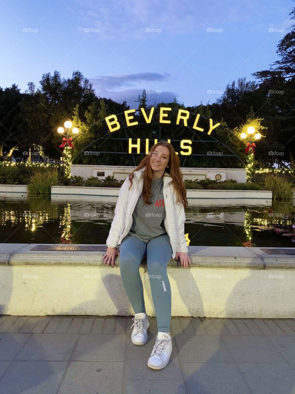 Beverly Hills photograph of a young redheaded girl sitting by the iconic sign 