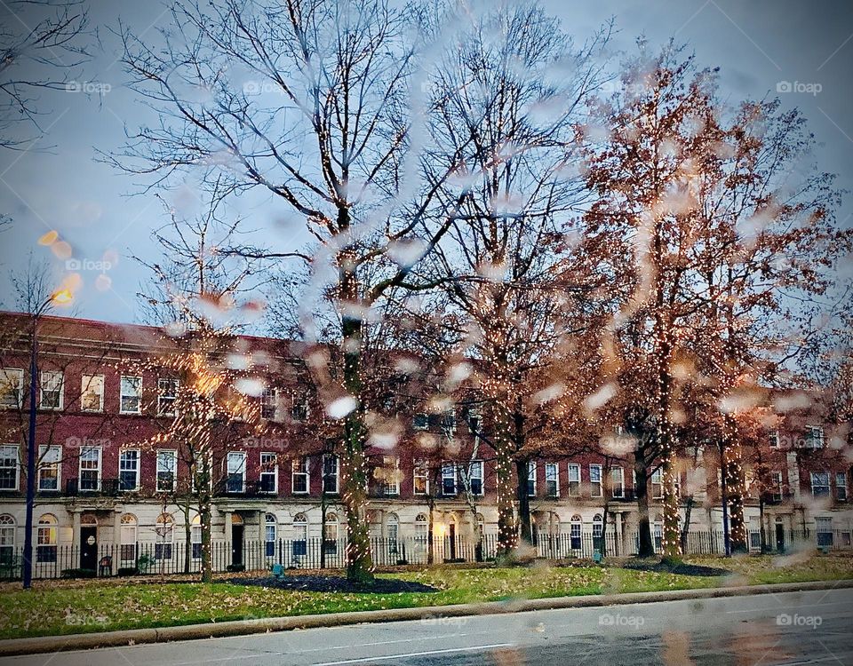 Early morning rain. Water droplets on the windshield, as we drive past the condos by the mall. 