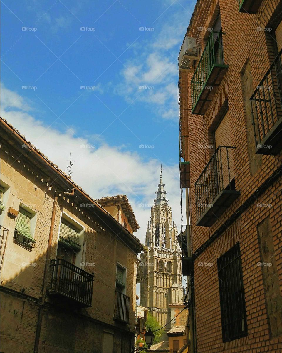 Gothic tower of the Cathedral as seen from a narrow street in Toledo, Spain.