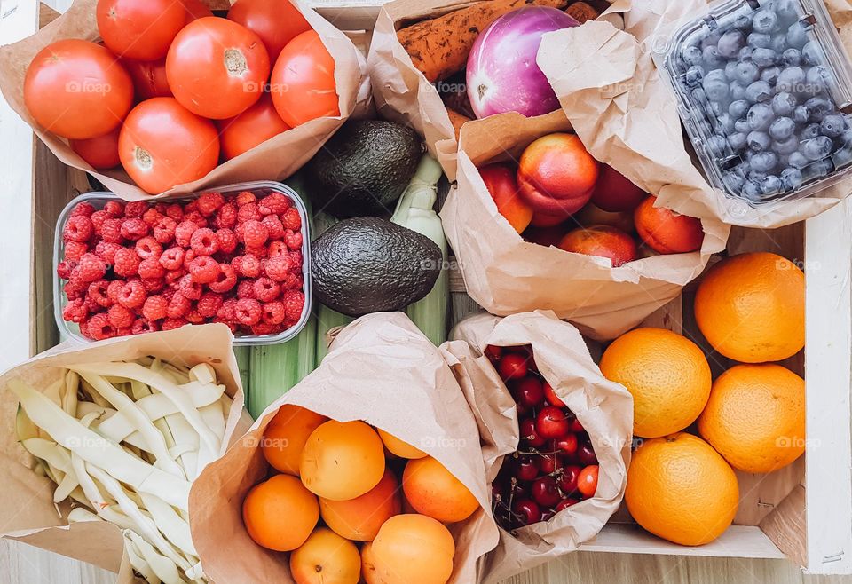 Top view of box with fresh fruits and vegetables.