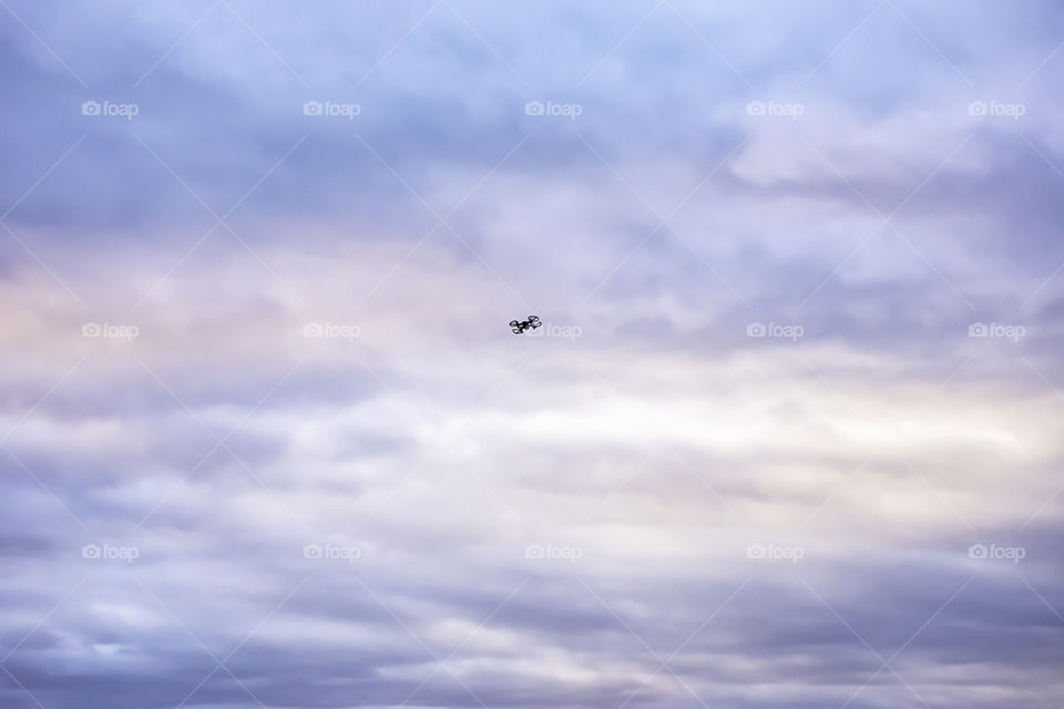 Black drones flying in the sky With many cloud and morning light.