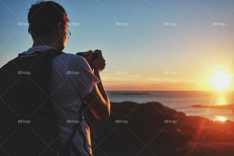 Man taking photos during sunset