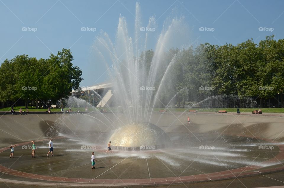 Children play in a huge water fountain in a state park in Seattle, Washington.