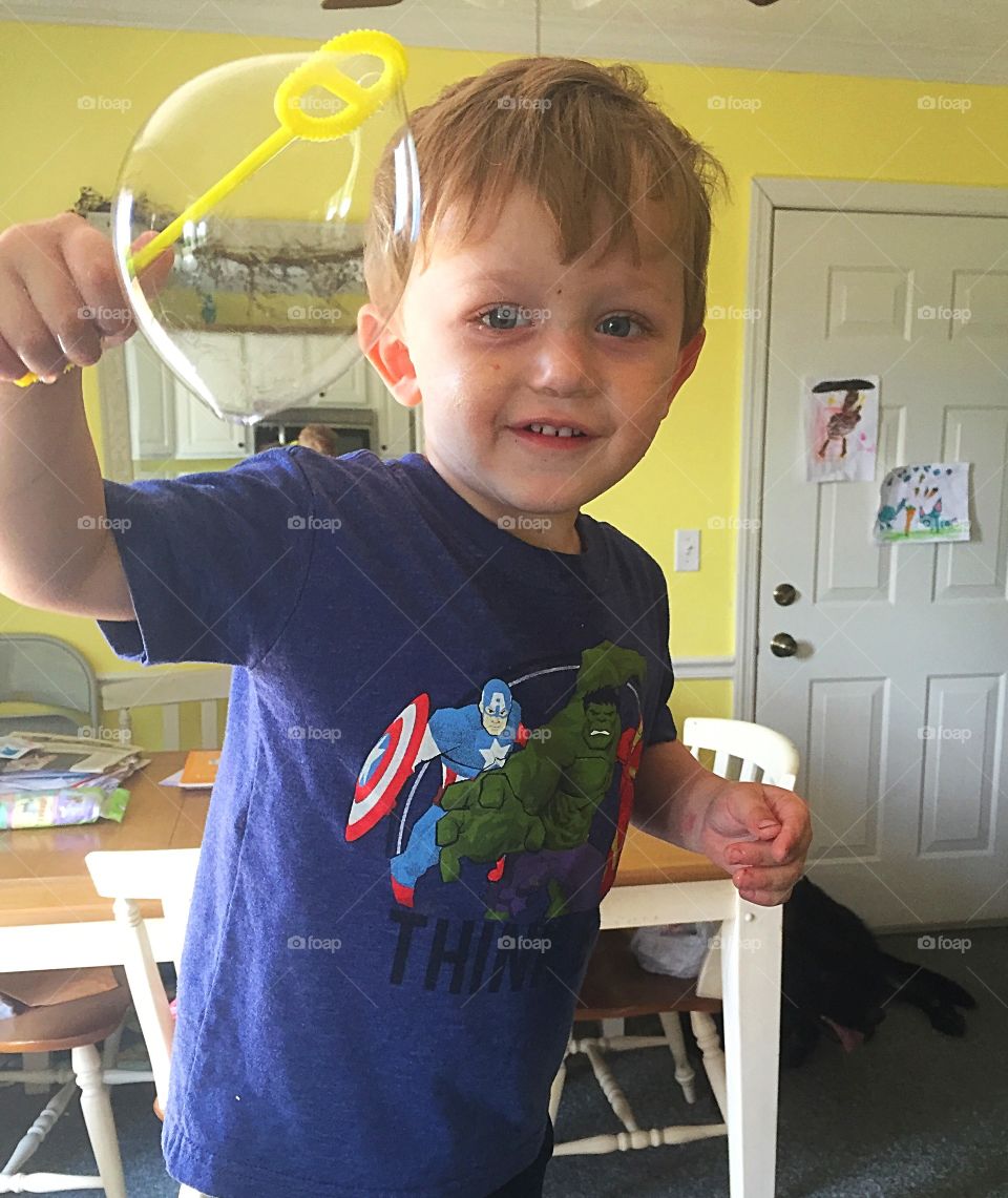 A two-year-old little boy showing off his bubble blowing skills. 