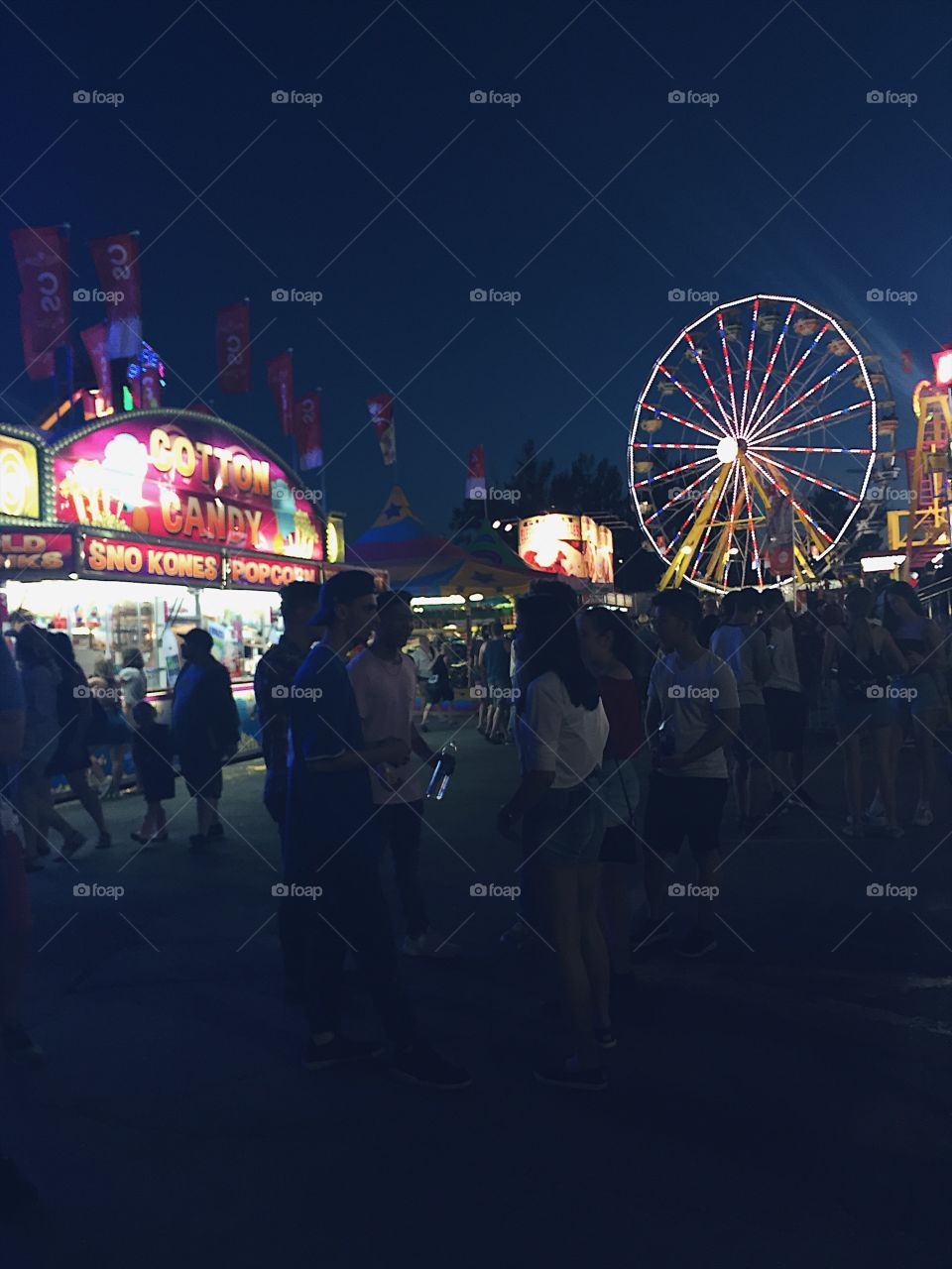 A whimsical evening on a midway, featuring a neon Ferris wheel and an abundance of carnival snacks.   