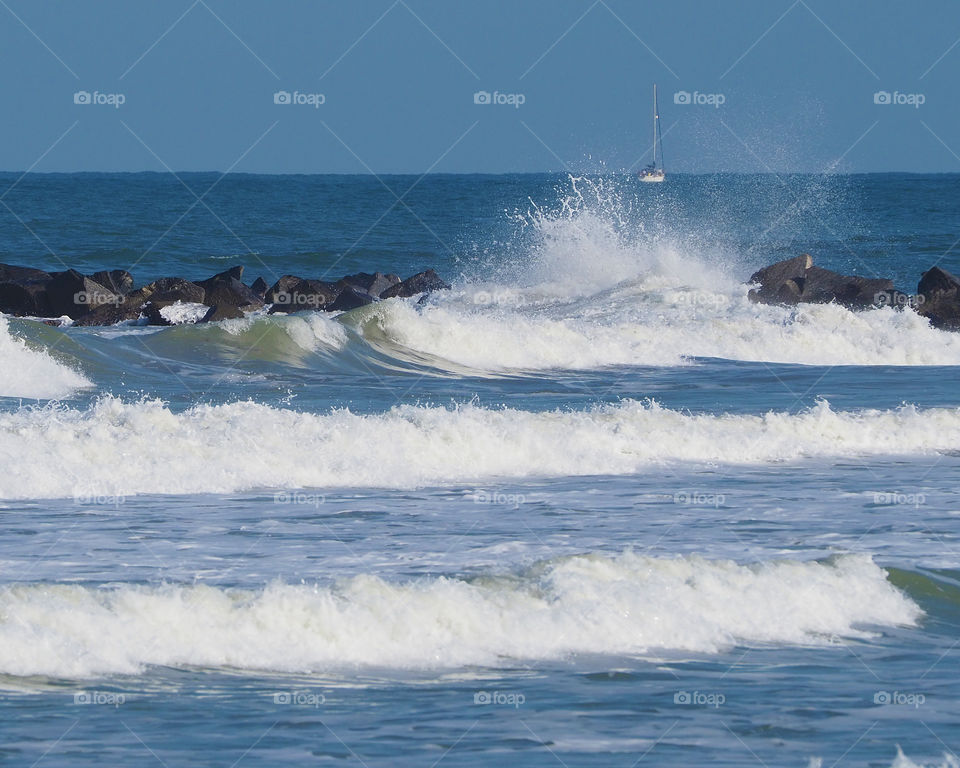 Waves, rock wall and a boat