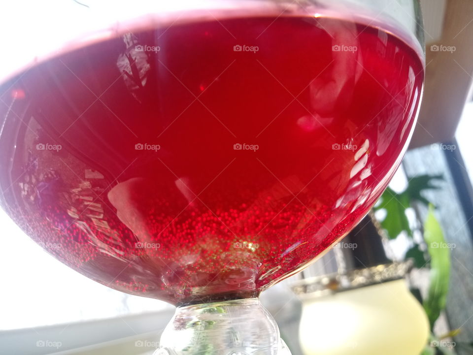 hibiscus ginger red soda with bubbles in wine glass close-up