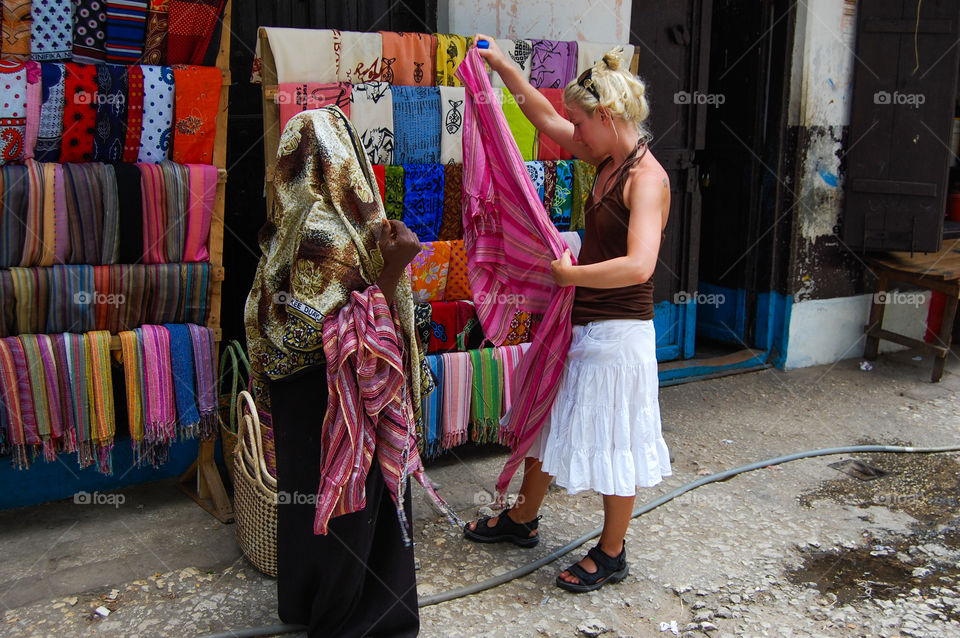 Young woman is bying a scarf in Stonetown Zanzibar.