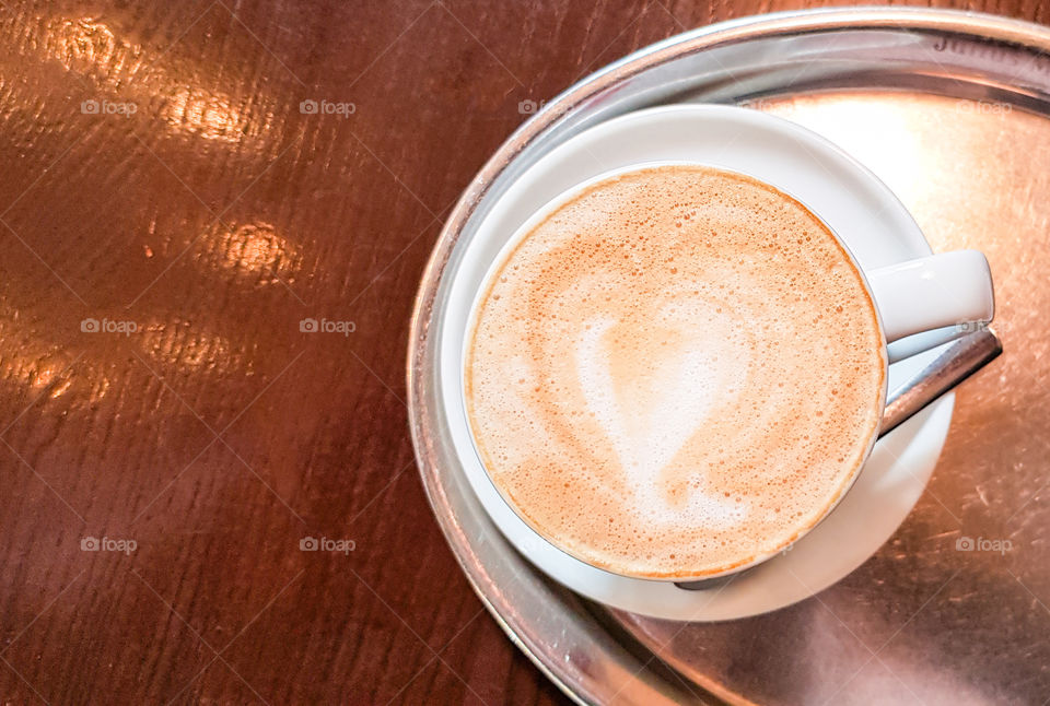 Top view of cup with cappuccino with almond milk.