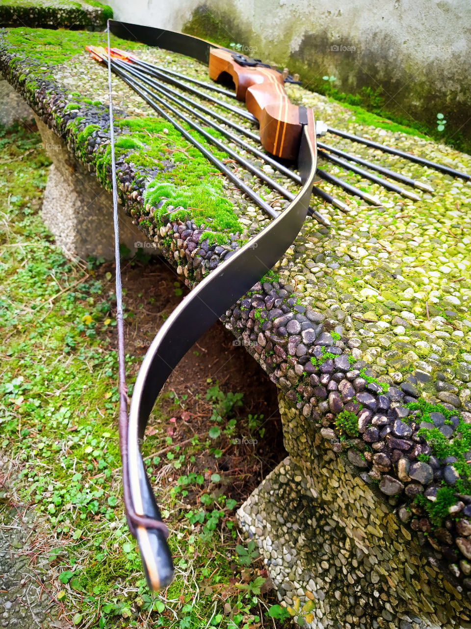 Bow for shooting and arrows on a stone bench