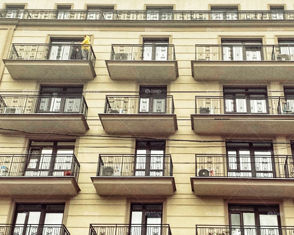 building with balcony architecture man yellow
