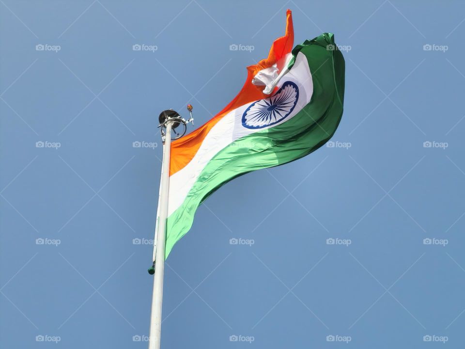 Indian flag high and brightly lit with sunlight