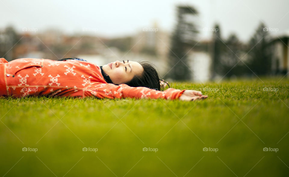 Young woman lying on grass in park