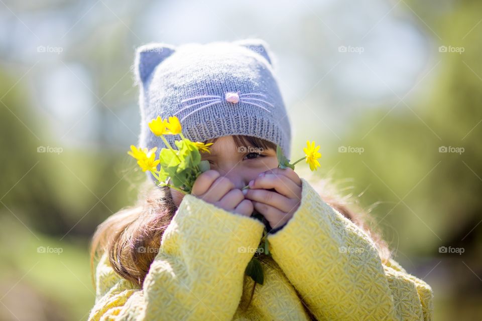 Little girl with yellow spring flowers 