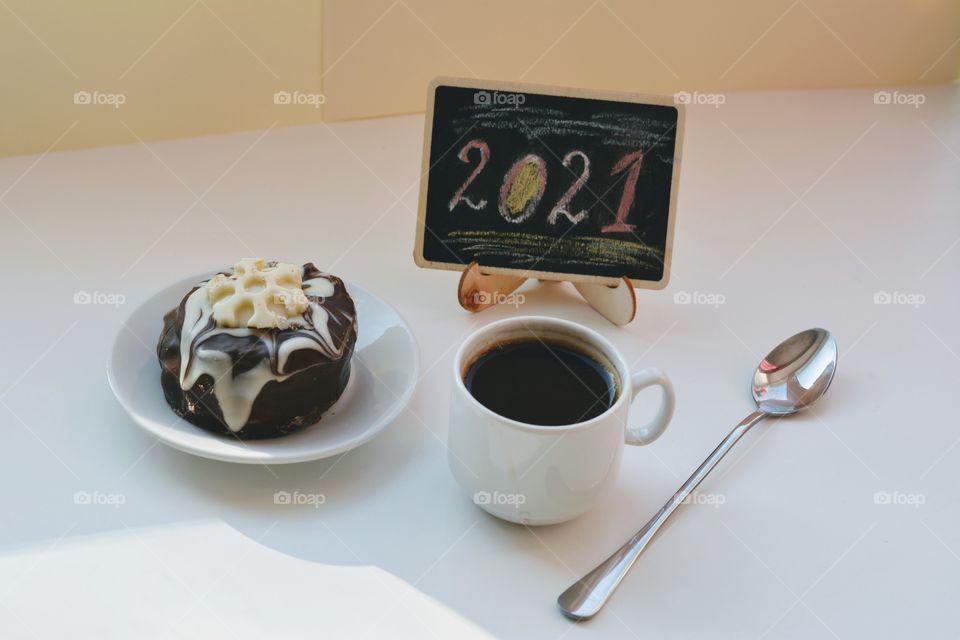 coffee cup and cake on a white table background, 2021