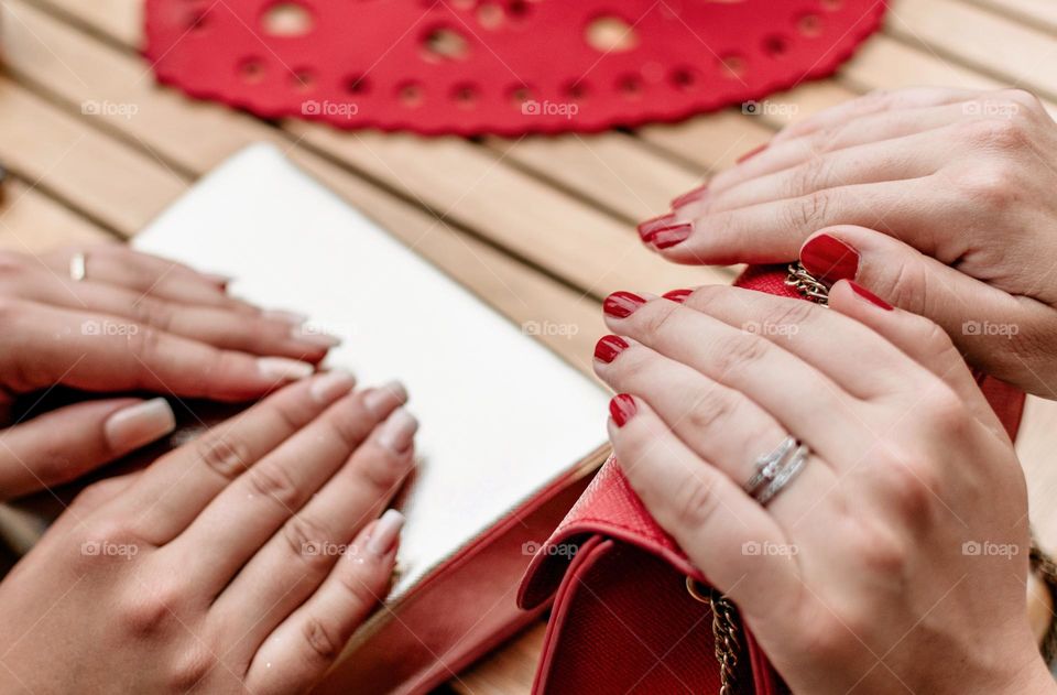 Close-up photo of two pairs of hands with painted nails